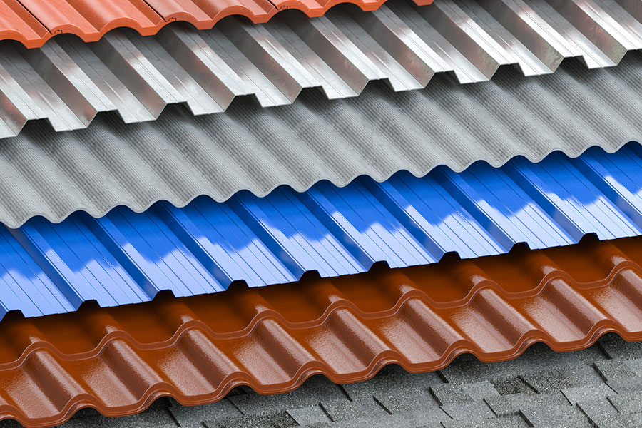 Stacks of metal roofing sheets in various colors—red, blue, and gray—are arranged in overlapping layers with wavy, corrugated profiles, highlighting the versatility of metal roofs for roof comparison with shingle roofs.